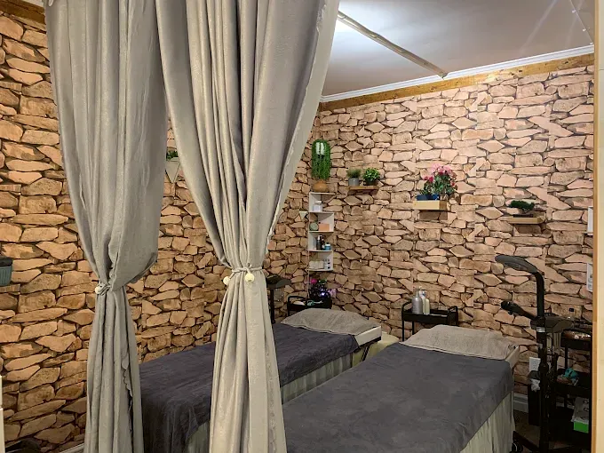 Private facial room with draped curtains and two treatment beds