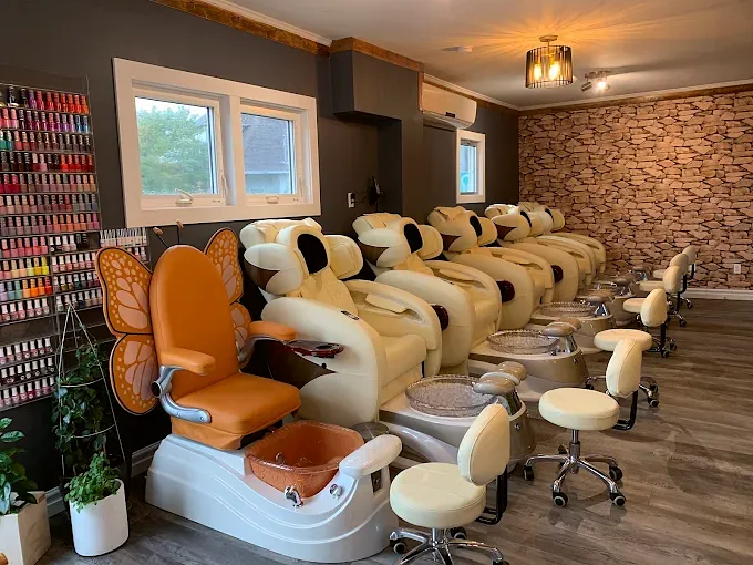 Row of cream pedicure chairs with a stone feature wall