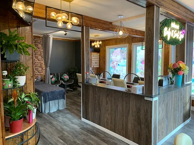 Reception desk with fresh flowers and plants, nail stations behind